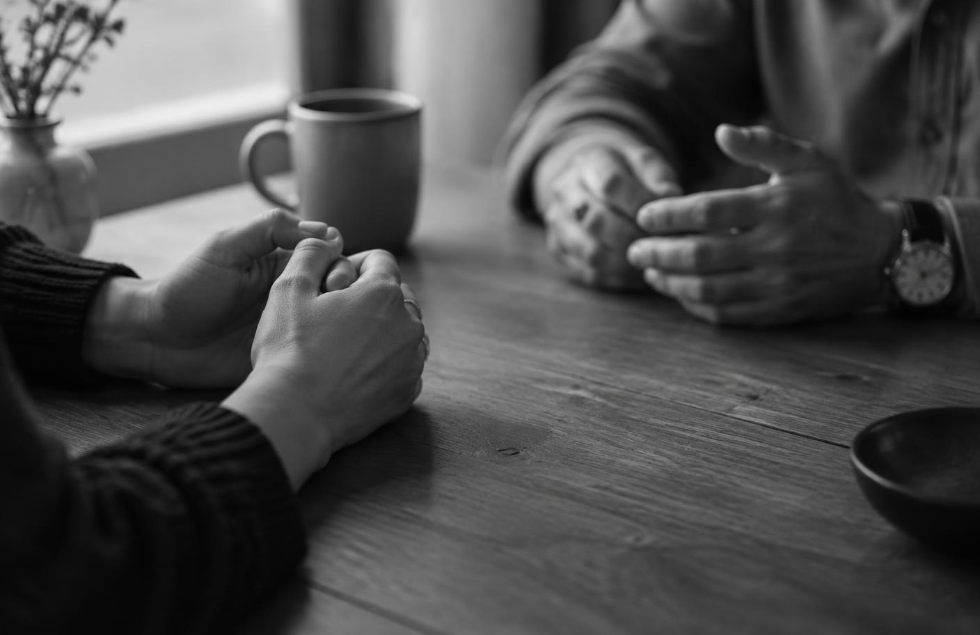 Two people speaking privately across a table